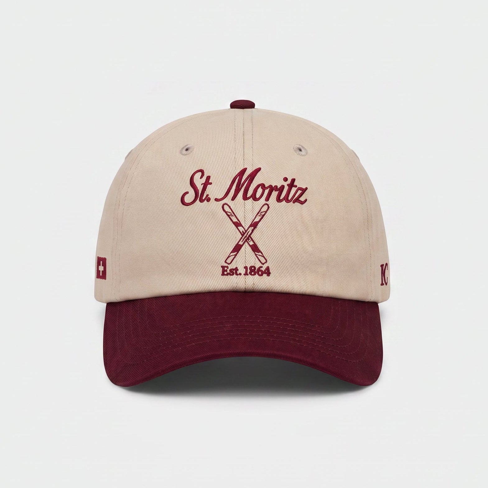 Beige and maroon cap with 'St. Moritz' text on a white background